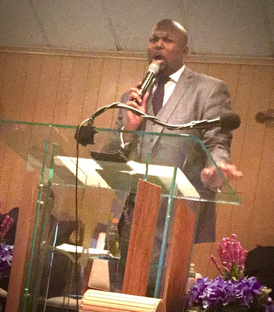 Pastor Charles preaching from the pulpit
