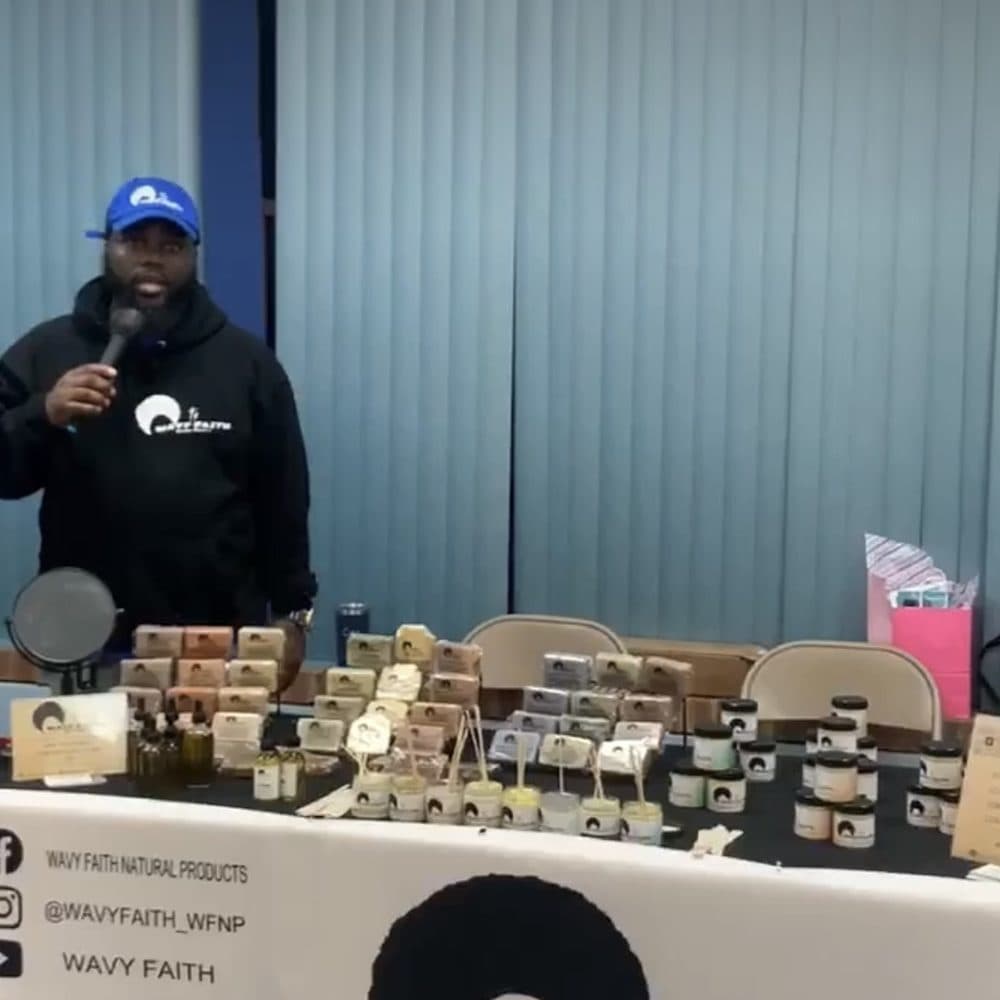 A small business owner presenting his products at the Latter Rain Marketplace